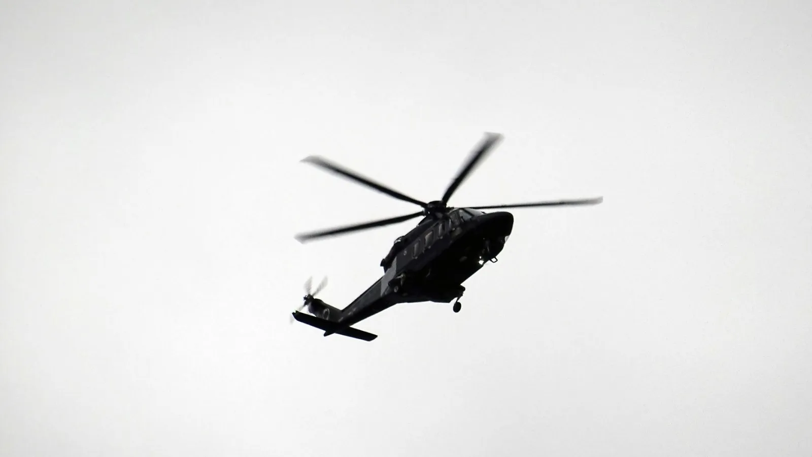 Hubschrauber fliegt gegen hellen Himmel