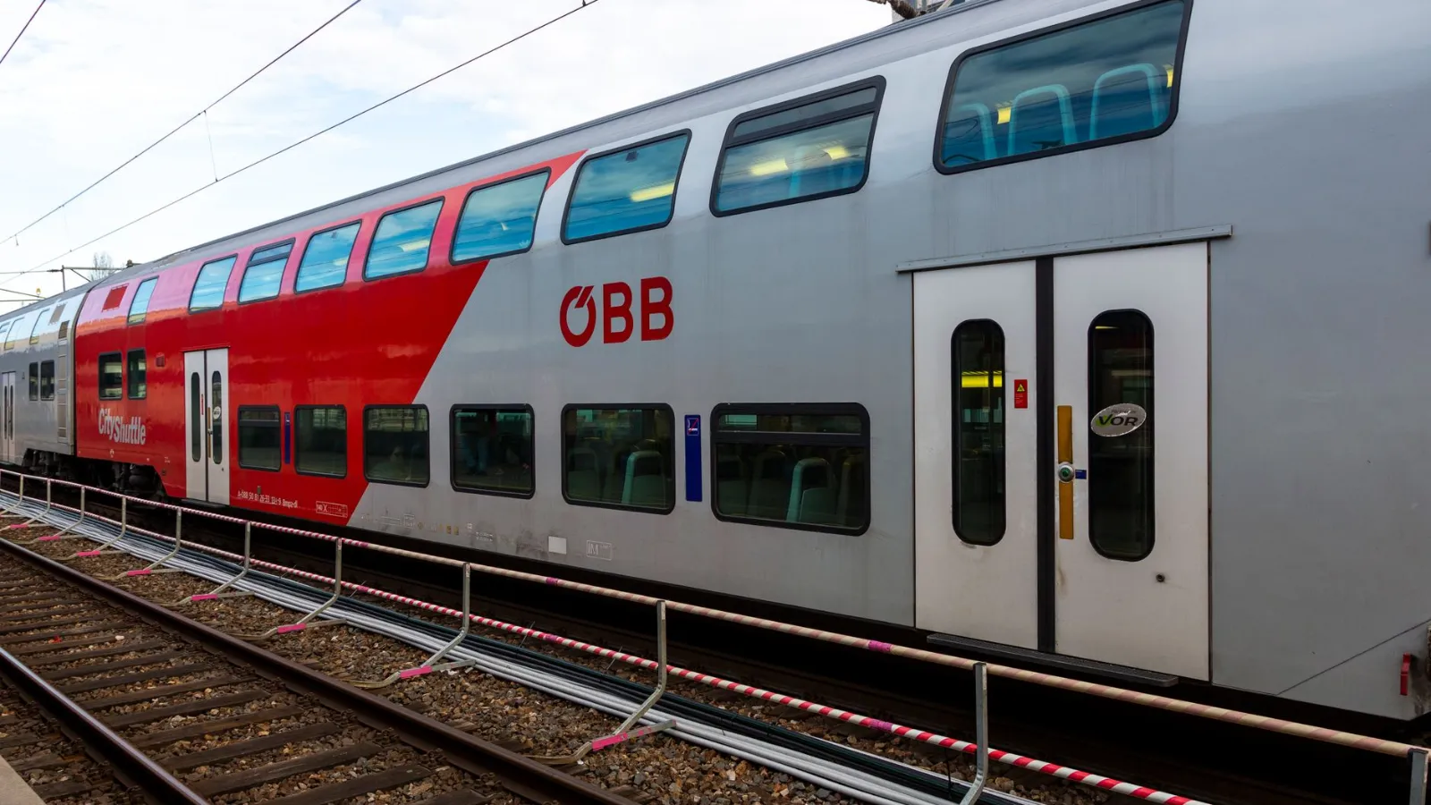 ÖBB Cityjet Doppelstockzug mit roten und silbernen Elementen auf Bahngleis