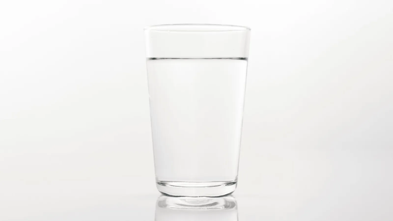 Glas mit Wasser auf hellem Hintergrund
