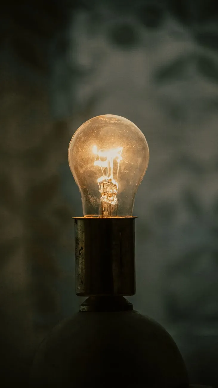 Glühbirne leuchtet in der Dunkelheit mit einem warmen, gelben Licht.