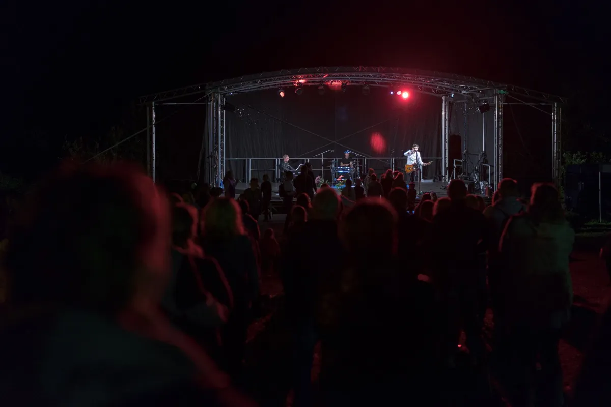 Konzertband spielt auf Open-Air-Bühne in Niederösterreich vor Publikum im Dunkeln
