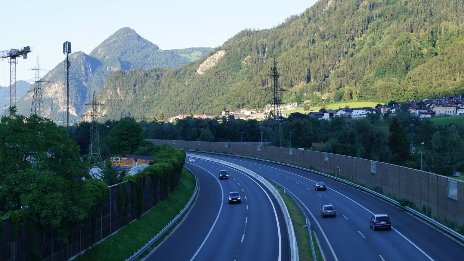 Autobahn mit Autos und Berglandschaft mit Häusern in Österreich