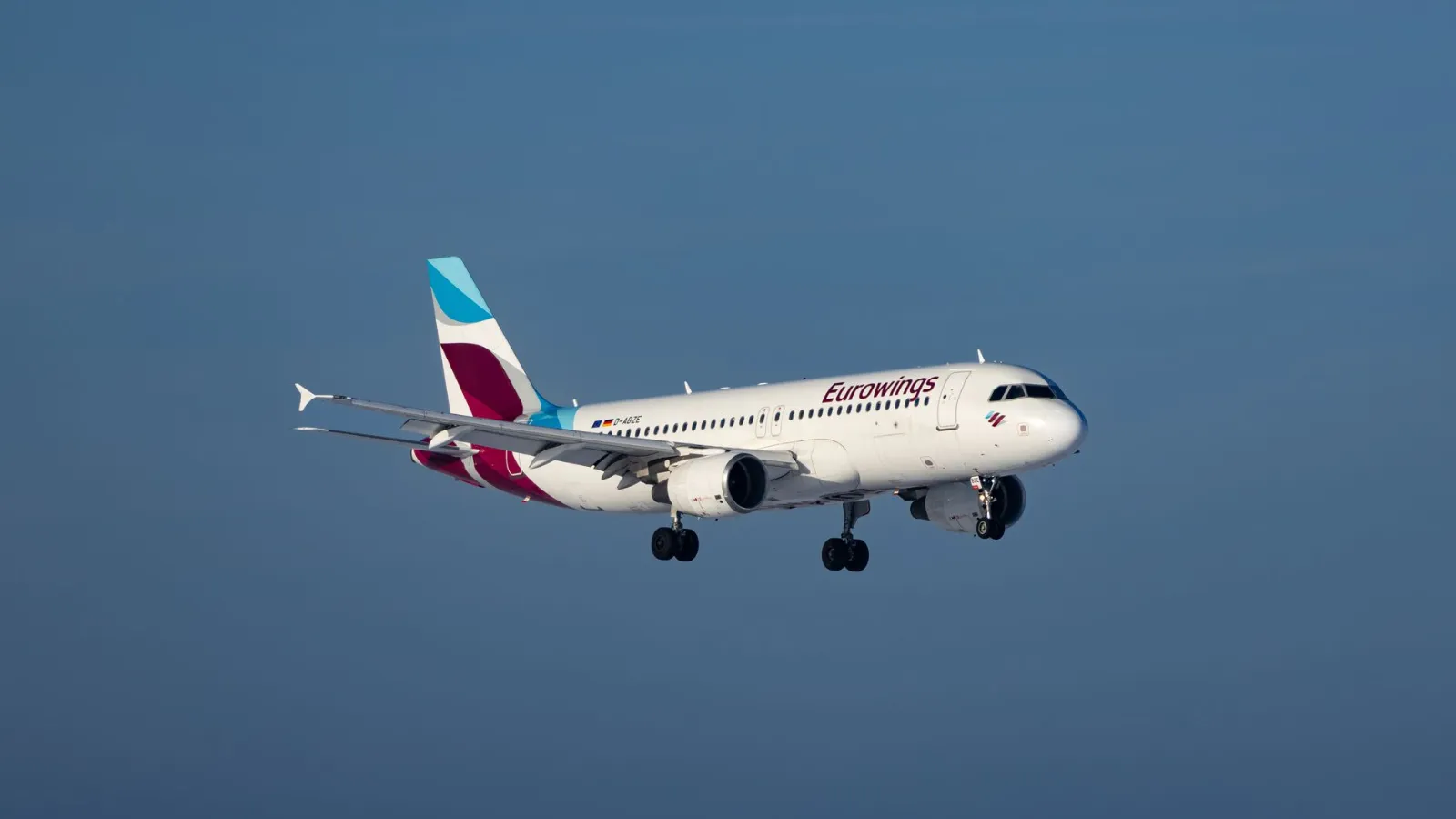 Eurowings Flugzeug im Flug vor blauem Himmel mit ausgefahrenem Fahrwerk