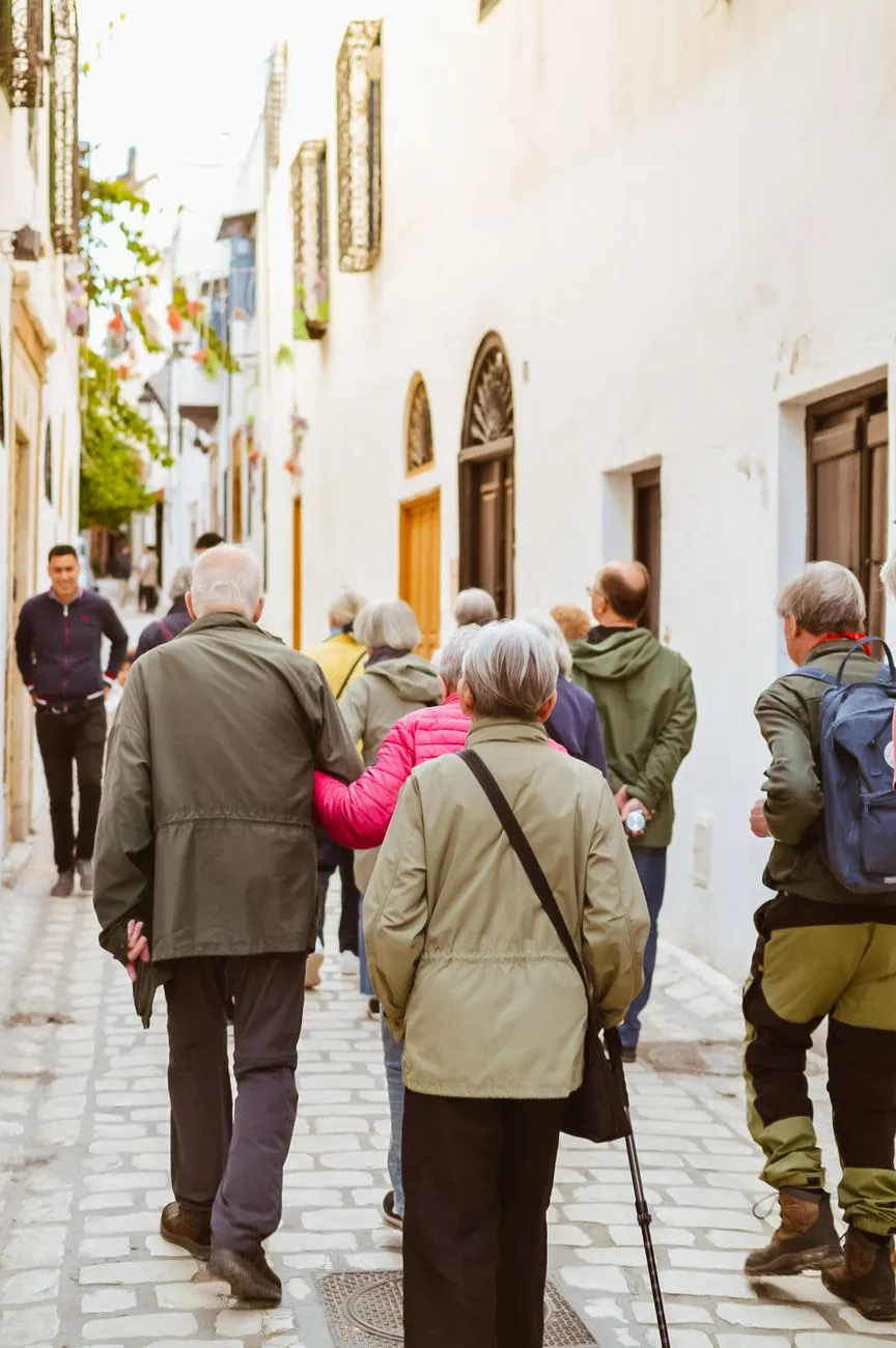 Senioren spazieren durch eine Gasse in einer mediterranen Stadt