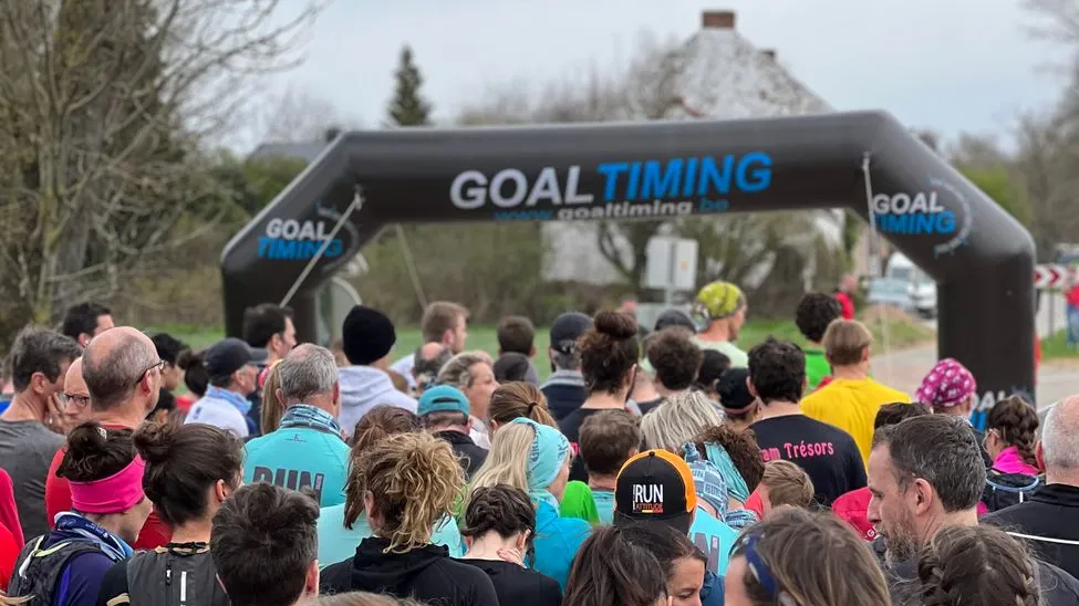 Läufer stehen vor aufblasbarem Zielbogen mit „GOAL TIMING“ Schriftzug, Outdoor-Event