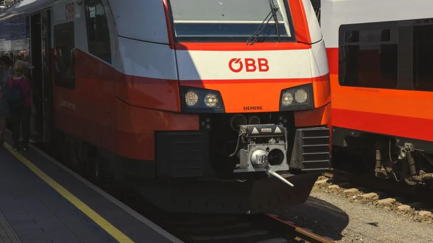 ÖBB-Zug mit Siemens-Logo am Bahnhof, Personen steigen ein