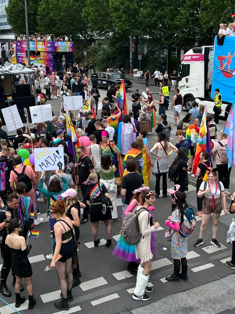 Parade mit Regenbogenfahnen und bunt gekleideten Menschen in Wien