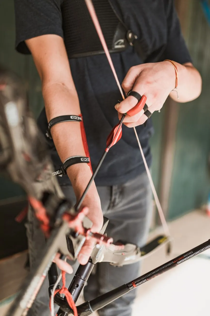 Bogenschütze mit Pfeil und Bogen im Detail, Hände mit Fingerschutz und Armschutz