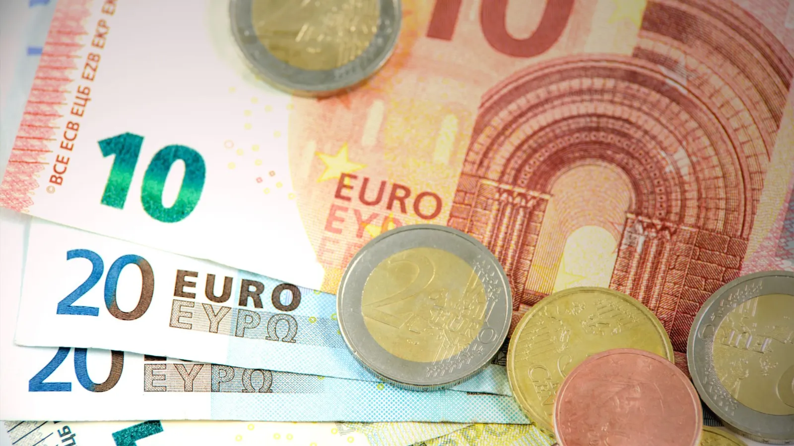 Euro-Banknoten und -Münzen auf hellem Hintergrund