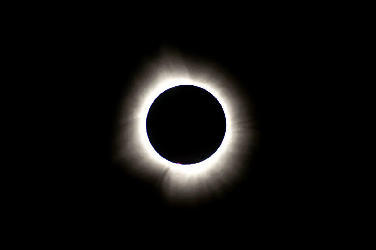 Sonnenfinsternis: Der Mond bedeckt die Sonne, der Korona leuchtet hell am dunklen Himmel.