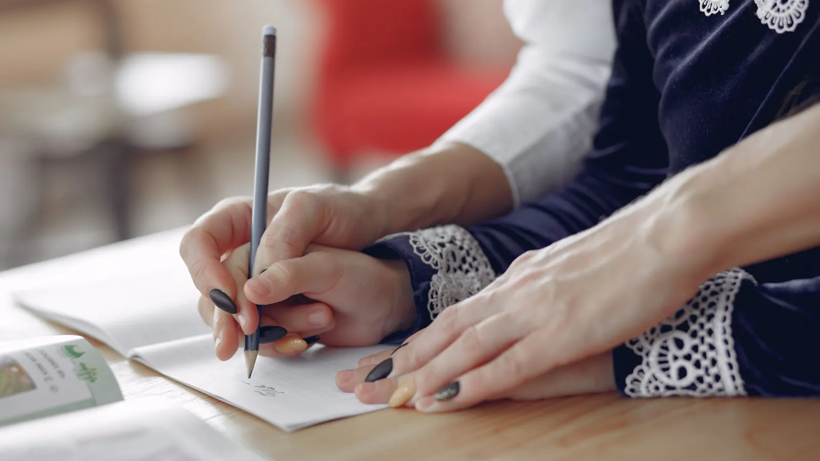 Hände schreiben mit Bleistift auf Notizbuch, Mann hilft Frau