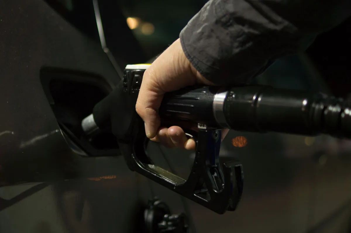 Tanken: Hand hält Zapfpistole beim Betanken eines Autos an einer Tankstelle